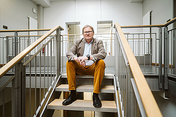 Prof. Dr. Oliver Rump © HTW Berlin_Alexander Rentsch Oliver Rump sitzt auf einer Treppe